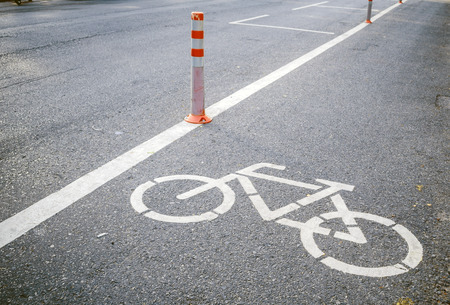 bicycle lane sign on the road with pole