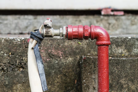 Old metal faucet and rubber tubeの写真素材