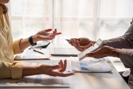 Closed up of business team male and female talking about figure, young business team working together at officeの写真素材