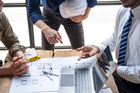 Closed up engineer meeting teamwork brain storm discussing for architectural project building construction work on blueprints and documentaryの写真素材