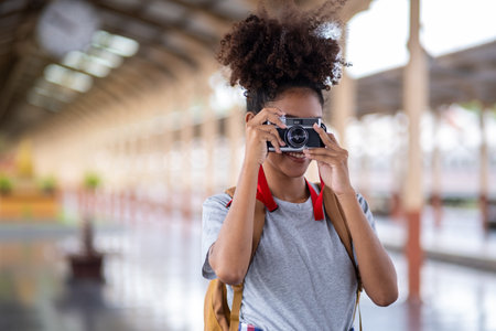 Young Asian African woman traveler with backpack in the railway train, traveler girl walking stand...