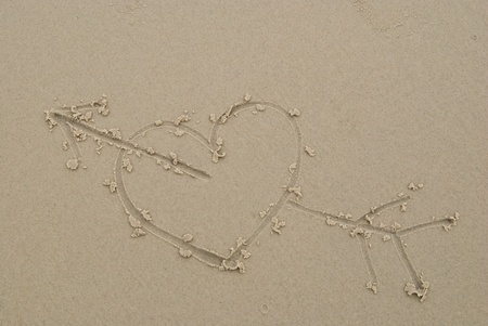 a heart drawn on the sand of a beachの写真素材