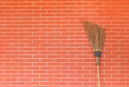 broom on red brick wallの写真素材