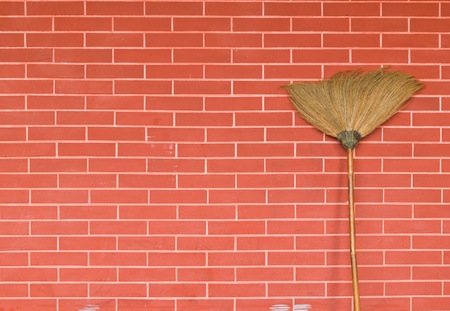 broom on red brick wallの写真素材