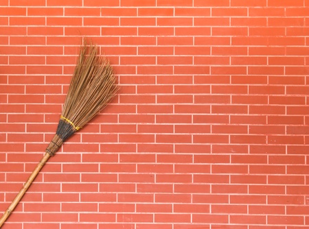 broom on red brick wallの写真素材