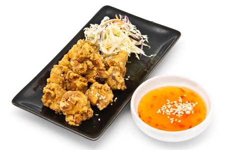 fried chicken in black plate with sauce on white backgroundの写真素材