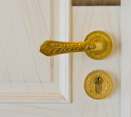 golden door handle and deadbolt on wooden doorの写真素材
