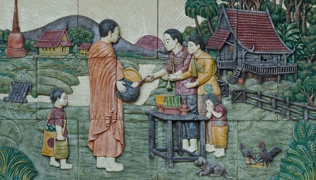 native culture Thai stucco on the temple wall,  Thailand, give food offerings to a Buddhist monk