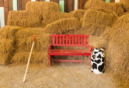 red wooden seat in dry straw  background at farmhouseの写真素材