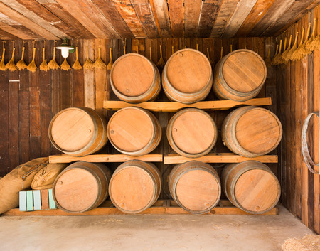 close up wine barrels stacked in old wine cave