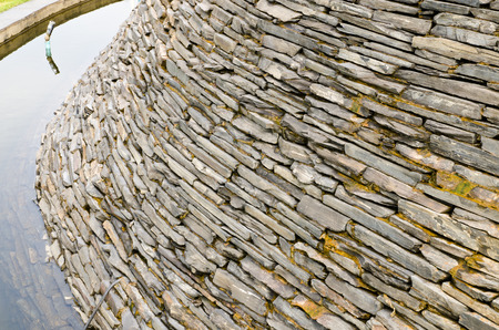 Decorative fountain wall with a slate stone in the gardenの写真素材