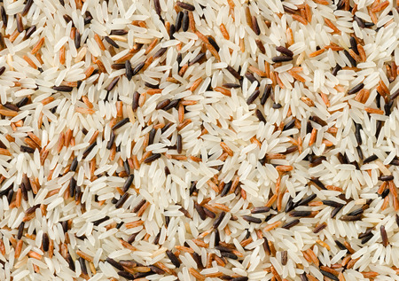 Food background with three mixed of Thai rice varieties : brown rice, mixed wild rice, white (jasmine) rice. species Oryza sativa.の写真素材