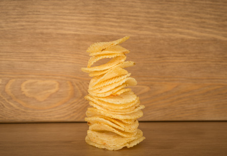 crispy potato chips on the wood table backgroundの写真素材
