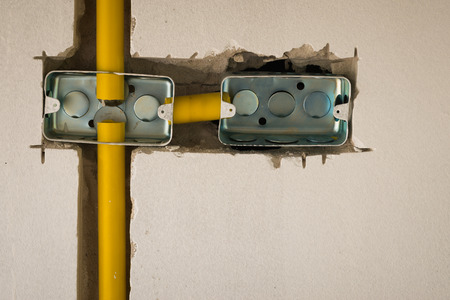close up two steel box electric socket installation inside masonry wall at  construction siteの写真素材