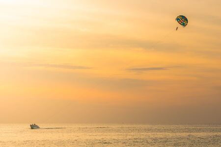 Tourists parasailing in sunset time at Phuket Beach, Thailandの写真素材