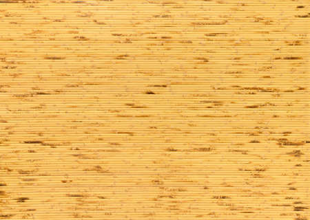 close up background and texture of decorative yellow bamboo wood on wall surface. bamboo finishing wall house background . bamboo line making from fire burn.の写真素材