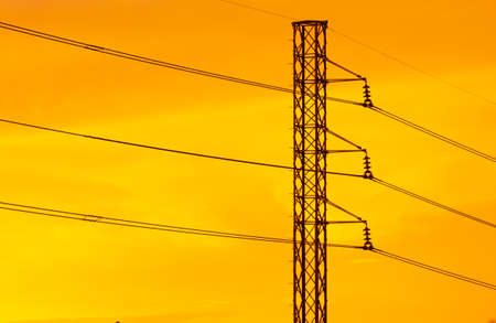 landscape view of electricity pylon in the city silhouetted against at the sunsetの写真素材