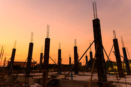 silhouette of a house column in construction site on  housing project at sunset