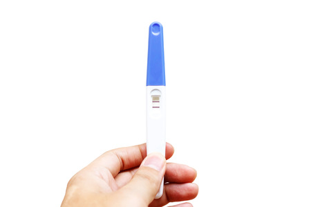 Woman is holding positive pregnancy test in her hand. Close-up. Isolated on white background.With clipping path.の写真素材