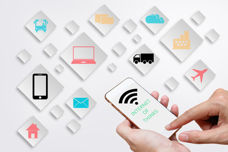 Internet of Things concept (IoT) with man hands holding smart phone in order to connect various...