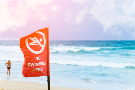 No swimming danger sign at the beach, warning sign at the beach with people swim, caution no swimming allowed.の写真素材