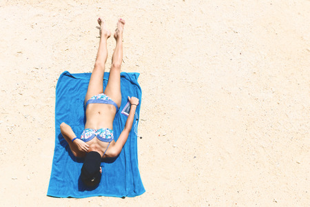 Top view and copy space of slim woman is lying sunbathe on the beachの写真素材