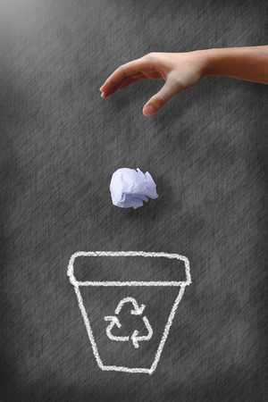 Man hand throwing wastepaper to recycle bin.の写真素材