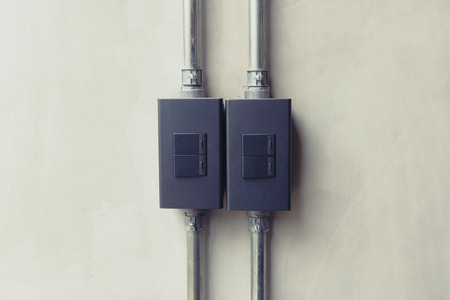 Close up of black lighting switch button on concrete wallpaper background with copy space.の写真素材