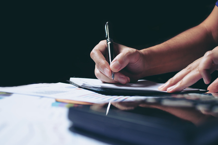 Calculator and woman hand doing finance with calculate about cost at home office.の写真素材