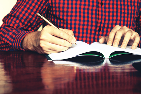 Young man writing note at home office.の写真素材
