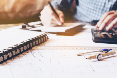 Architect engineer man calculate building area with equipment on desk.