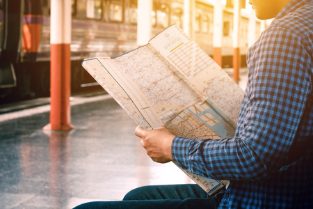 Asian man looking map with finding location for travel.の写真素材