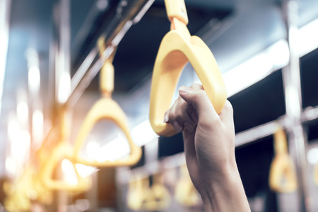Young passenger man hand holding handrail in subway.