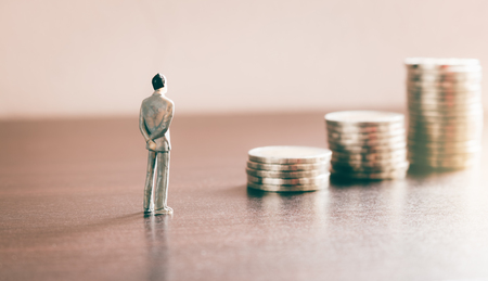 Miniature people looking future with stack coin about financial and money savings concept.の写真素材
