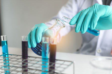 Scientific researcher or doctor pouring chemical substance test tube in laboratory.の写真素材