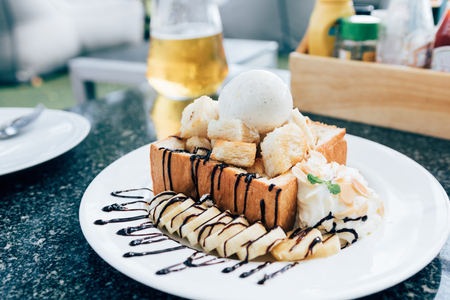Honey toast with banana and vanilla ice-cream.の写真素材