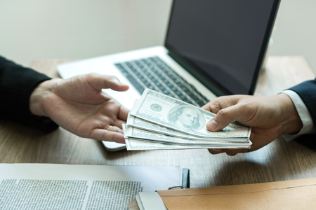 Entrepreneurs are receiving money that is a bribe of their partners with both of whom are corrupt in the company room.の写真素材