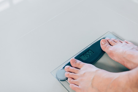 Close up of people feet standing on scale weighing.の写真素材