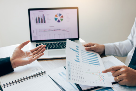 Two employees check the financial statements of the company together in the accounting room.