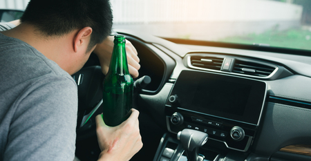 Asian men drink a lot of alcohol until and unconscious his can't drive home and decide to sleep at the steering wheel.の写真素材