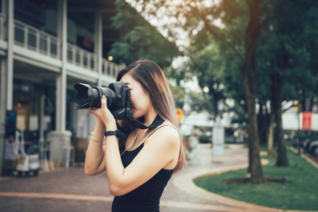 Asian female photographer with professional camera.の写真素材