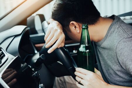 Asian men drink a lot of alcohol until and unconscious his can't drive home and decide to sleep at the steering wheel.の写真素材
