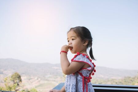 Girls children are enjoying eating strawberry with happy in garden.の写真素材