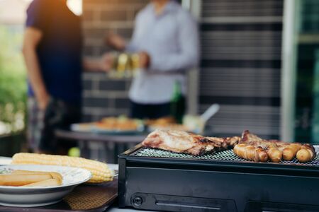 Close up grill with meat and sausage ready for socializing celebrate with friends at outsite home.の写真素材