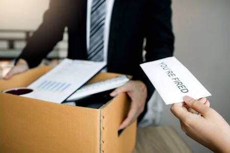 Female manager submits a resignation letter or envelope to the male employee at the office.の写真素材