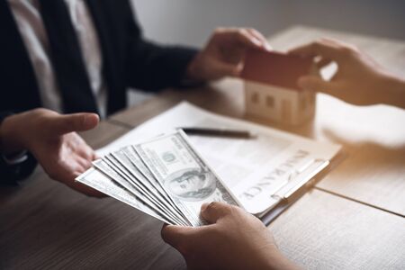 Home sales brokers and real estate investors are exchanging with investors being filing cash at the agent's hand.の写真素材
