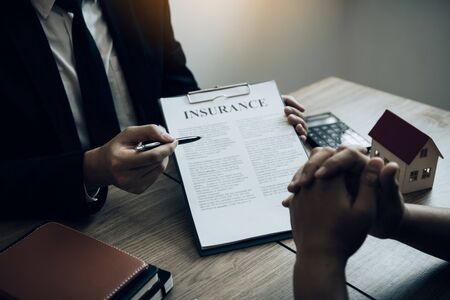 Agents are using pens pointing to insurance contracts and are being explained to customers at the office.の写真素材