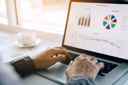 Investors are using laptop computers to analyze graphs in the morning.