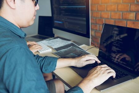 Two partnerships developing programming and coding technologies working on laptop and analyzing...