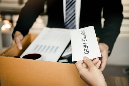 Female manager submits a resignation letter or envelope to the male employee at the office.の写真素材
